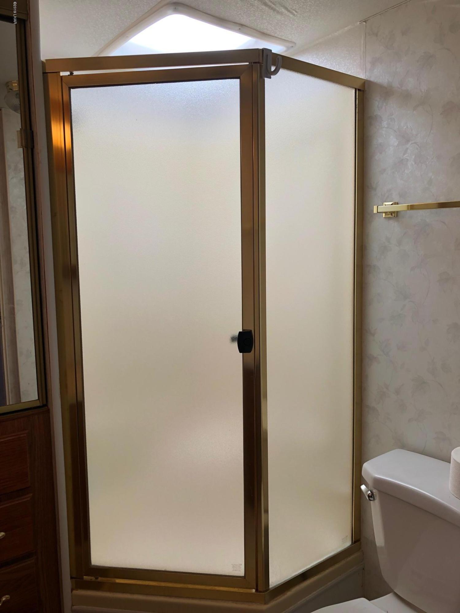 14106 Ashurst Road Yucca, AZ 86438 - Photo 5 of 17 a bathroom with a glass shower door