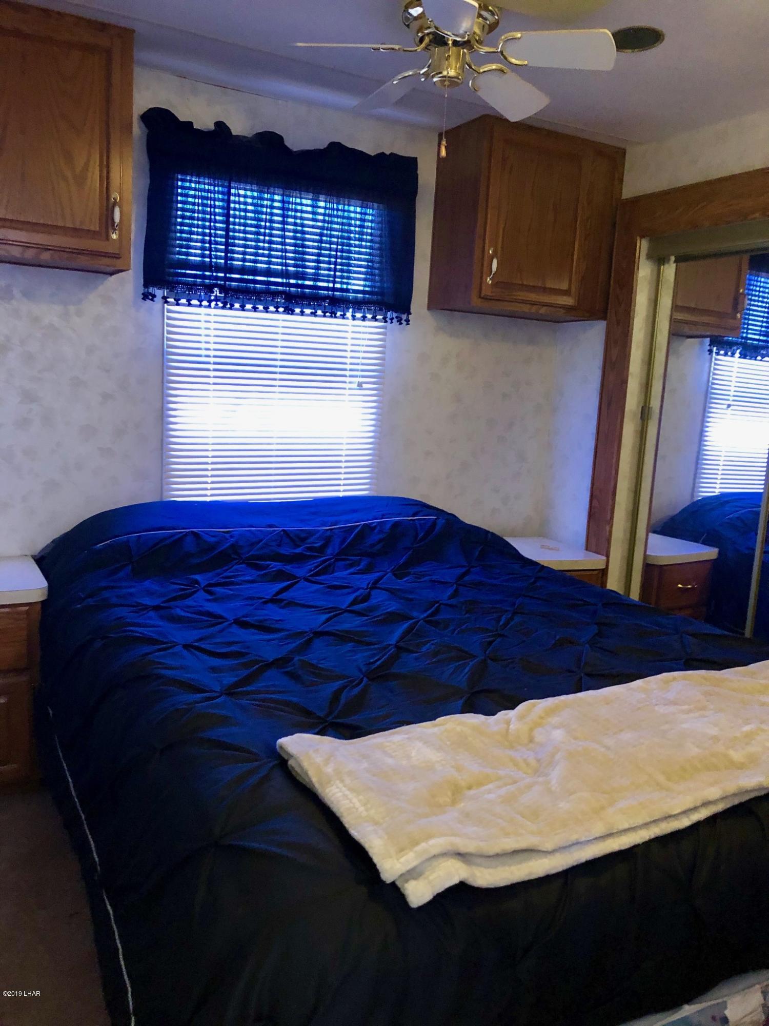 14106 Ashurst Road Yucca, AZ 86438 - Photo 6 of 17 a bedroom with a bed and a night stand