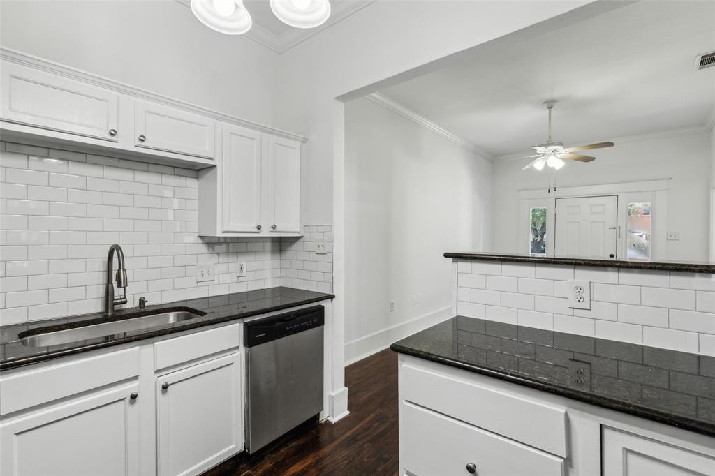 820 West 10th Street Dallas, TX 75208 - Photo 4 of 10 a kitchen with granite countertop white cabinets and white appliances