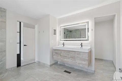 a spacious bathroom with a granite countertop sink a mirror and a bathtub