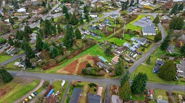 an aerial view of residential houses with outdoor space and trees