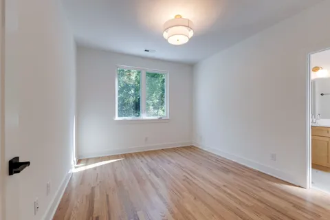 an empty room with wooden floor and mirror