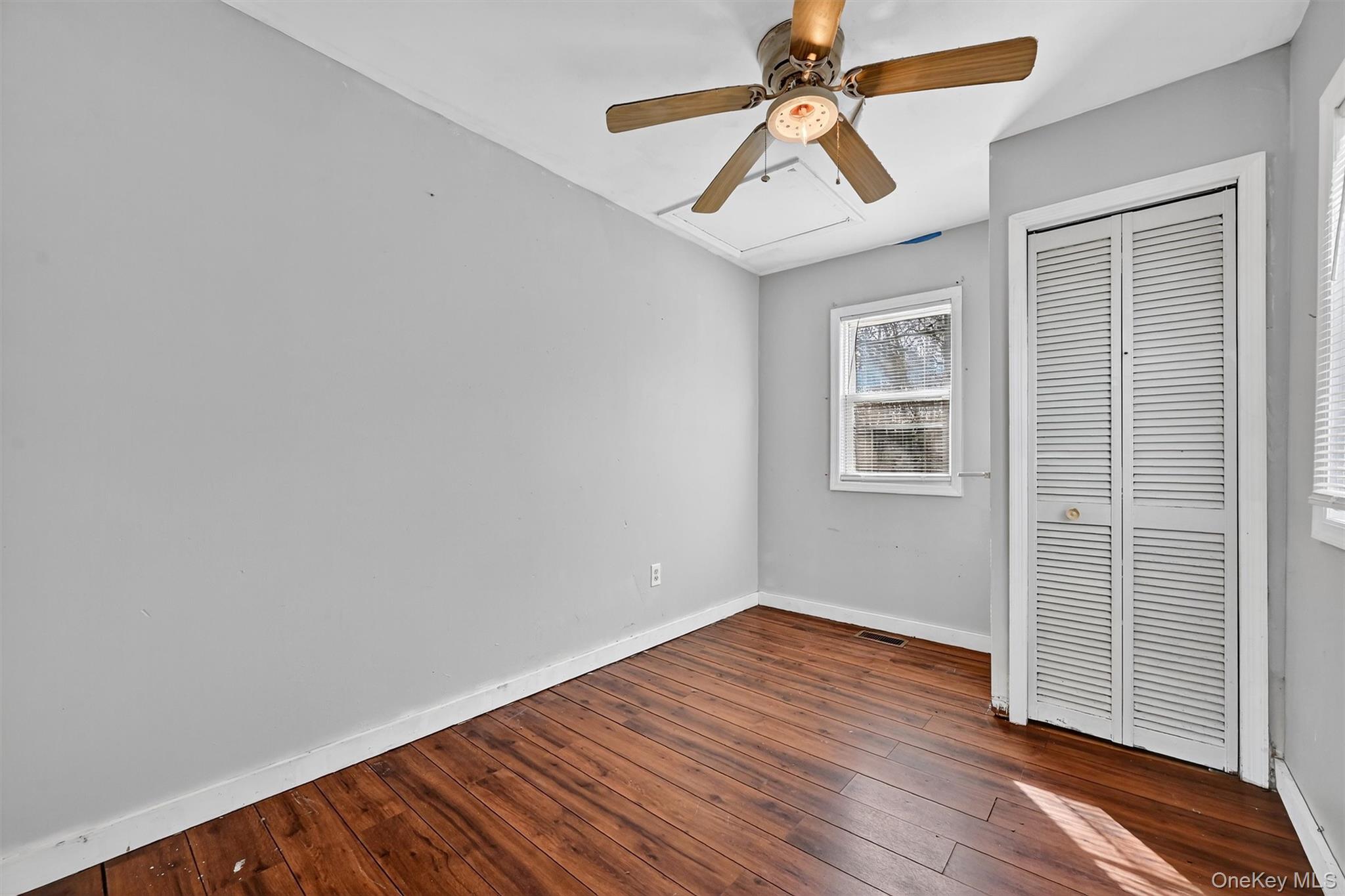 1187 Burlingham Road Pine Bush, NY 12566 - Photo 21 of 26 an empty room with wooden floor ceiling fan and windows