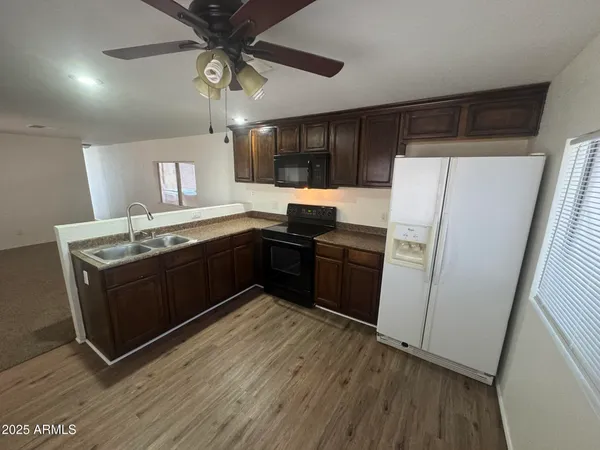 a kitchen with granite countertop a refrigerator a sink and dishwasher