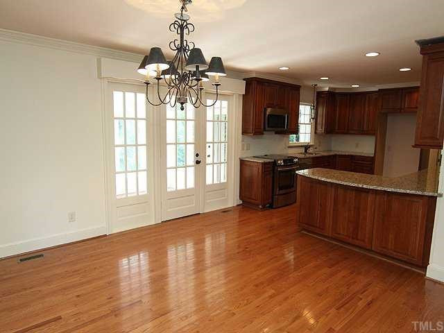 6616 Pleasant Pines Drive Raleigh, NC 27613 - Photo 5 of 15 Another view of kitchen showing eat in area and doors to sunroom. Kitchen
