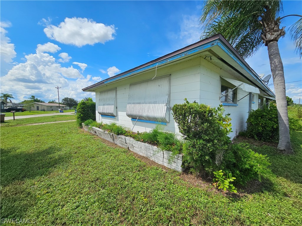 Undisclosed Address Lehigh Acres, FL 33936 - Photo 3 of 15 a yellow house with garden in front of it