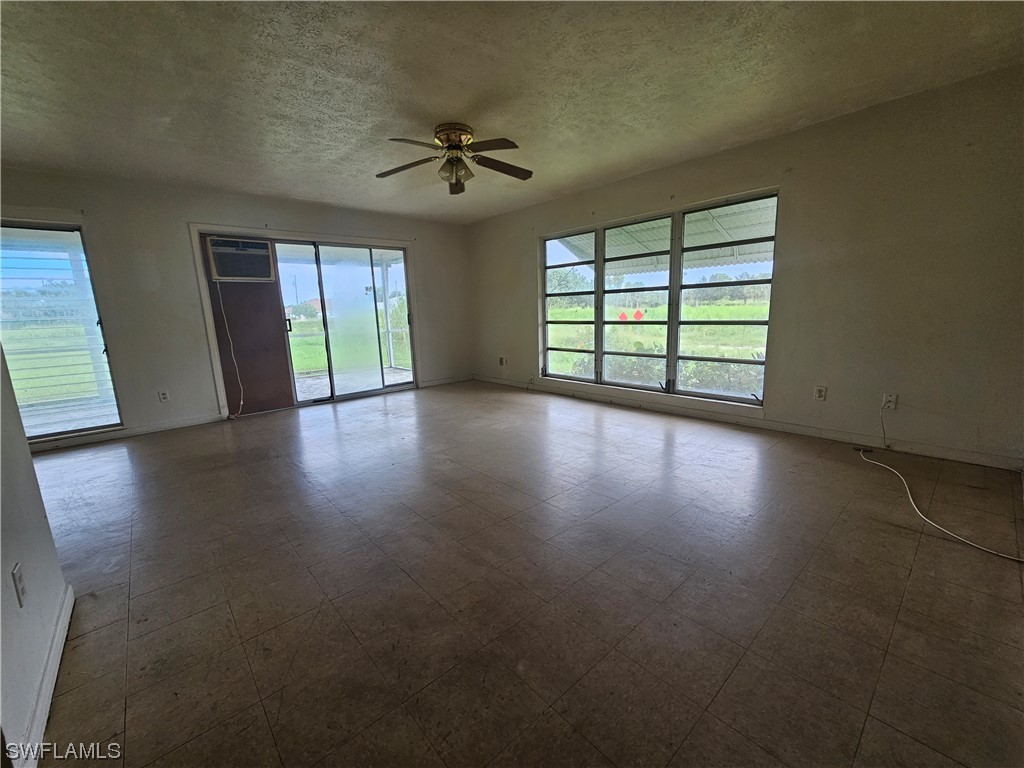 Undisclosed Address Lehigh Acres, FL 33936 - Photo 9 of 15 a view of an empty room with wooden floor and a window