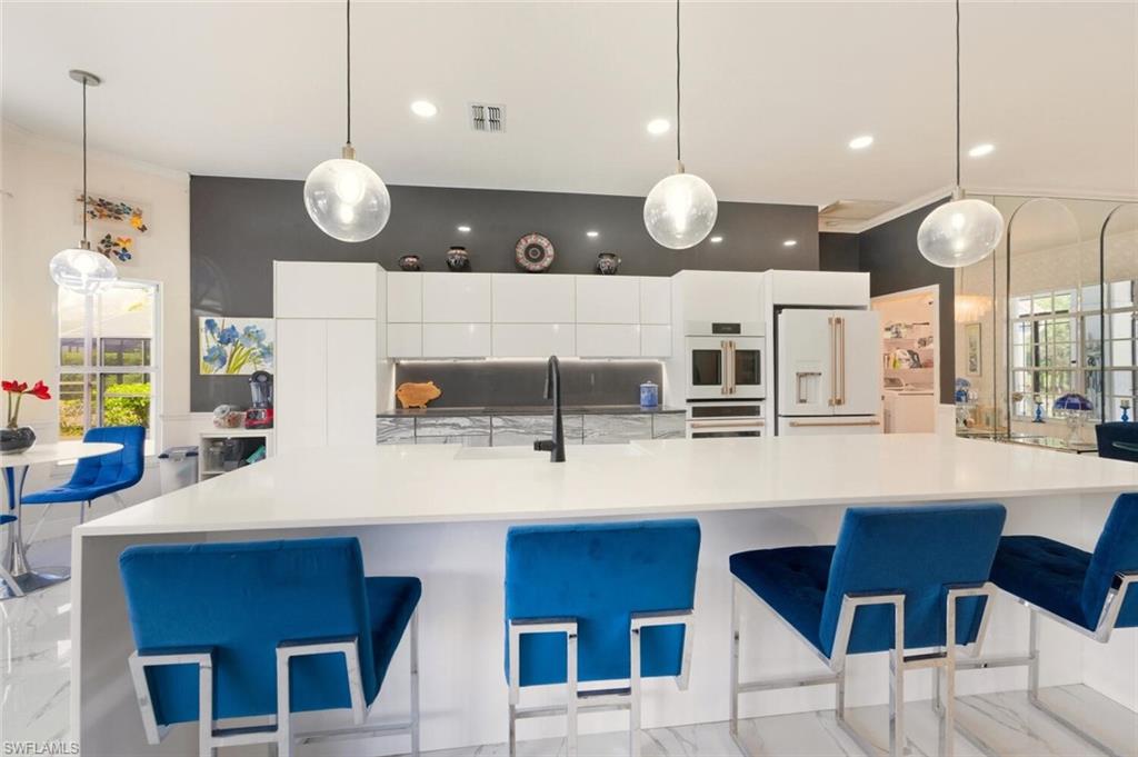209 Countryside Drive Naples, FL 34104 - Photo 9 of 50 a large kitchen with a table and chairs