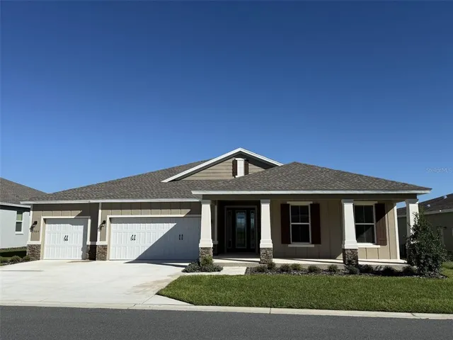 a front view of a house with garden and garage
