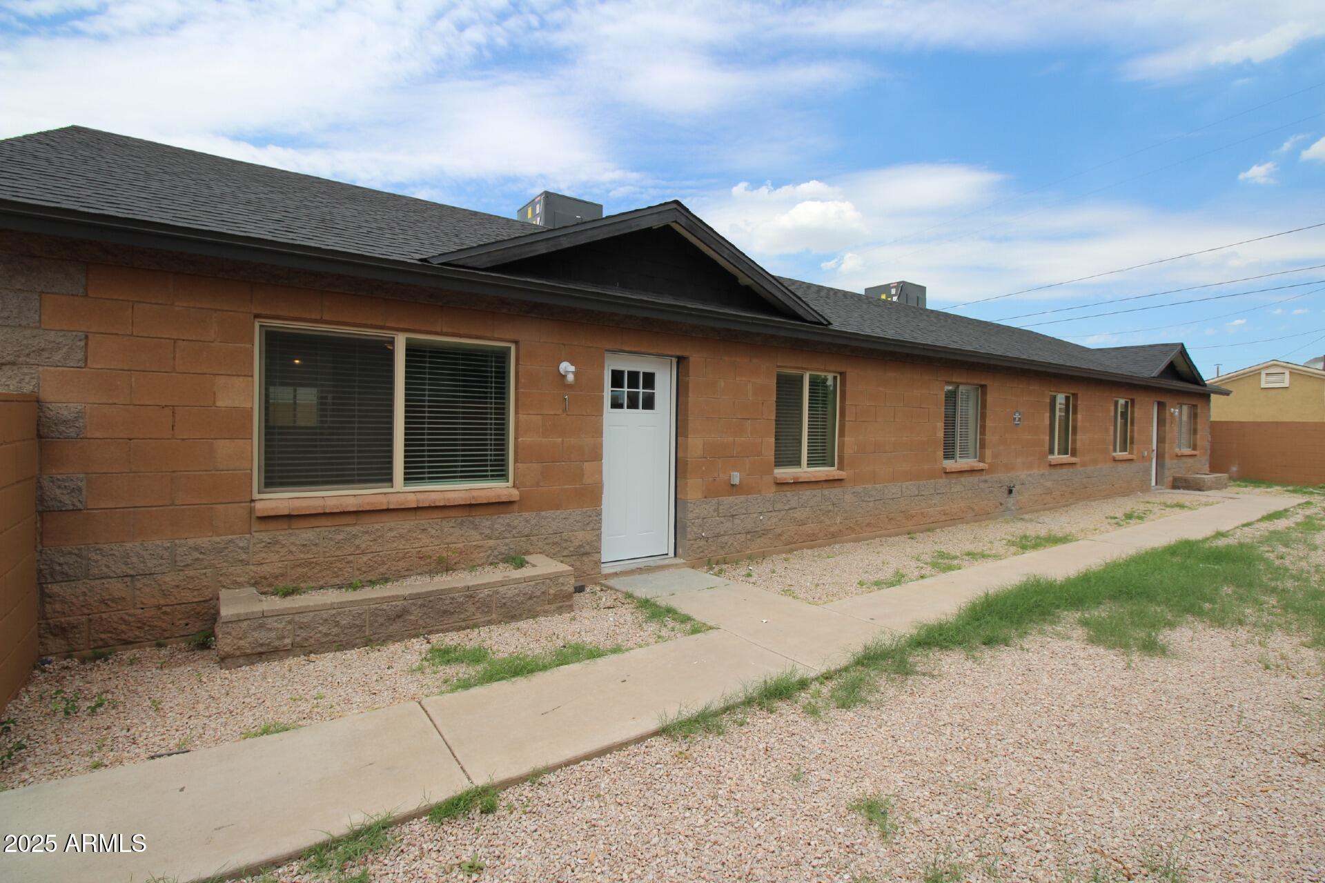 1732 West Maricopa Street, Unit 1 Phoenix, AZ 85007 - Photo 1 of 30 a front view of a house with a garden and garage