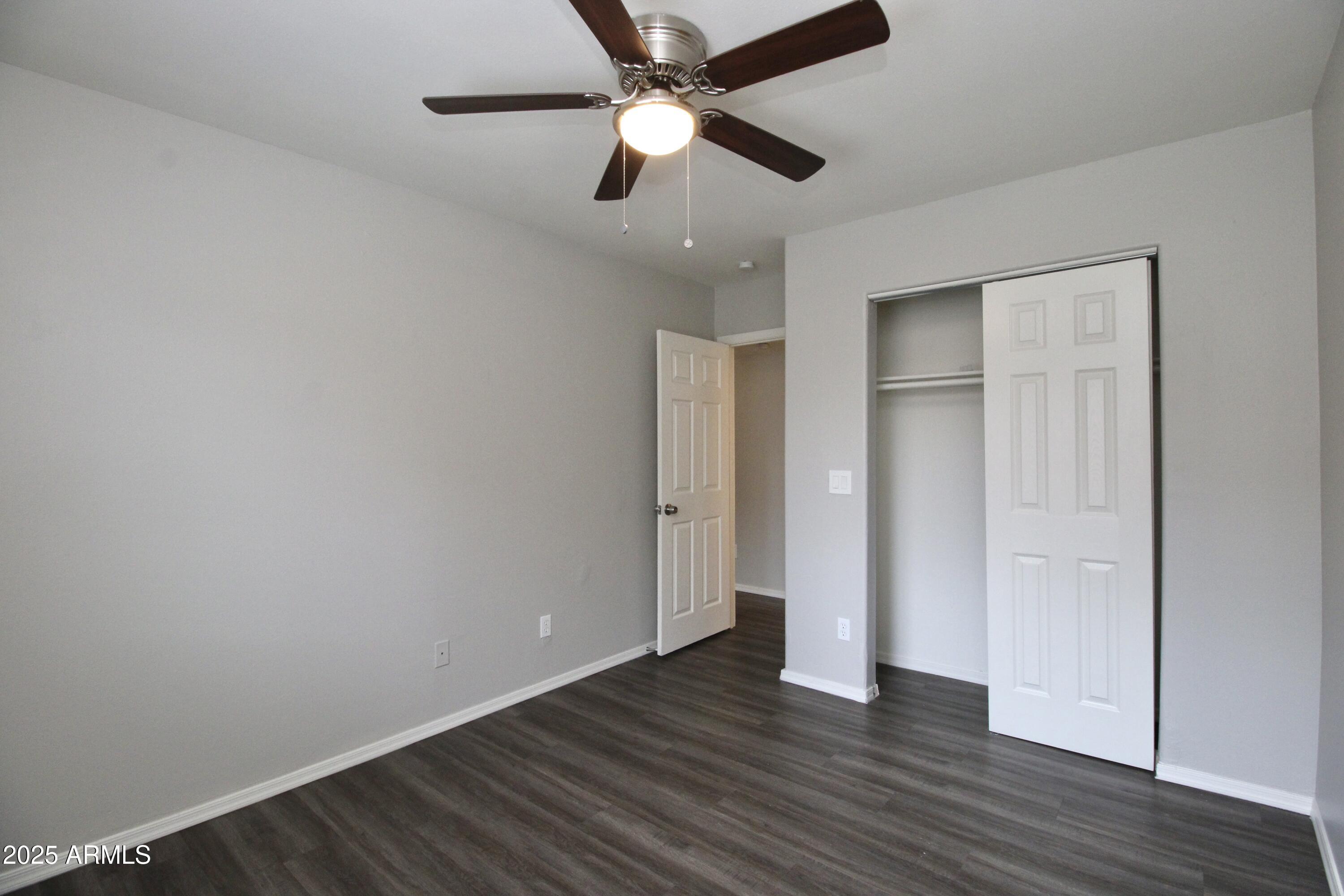 1732 West Maricopa Street, Unit 1 Phoenix, AZ 85007 - Photo 15 of 30 an empty room with wooden floor a ceiling fan and closet