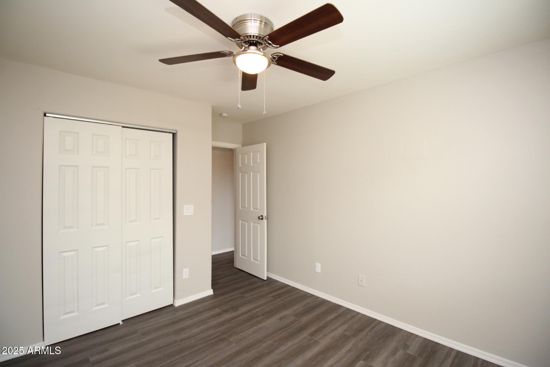 1732 West Maricopa Street, Unit 1 Phoenix, AZ 85007 - Photo 23 of 30 an empty room with wooden floor a ceiling fan and closet