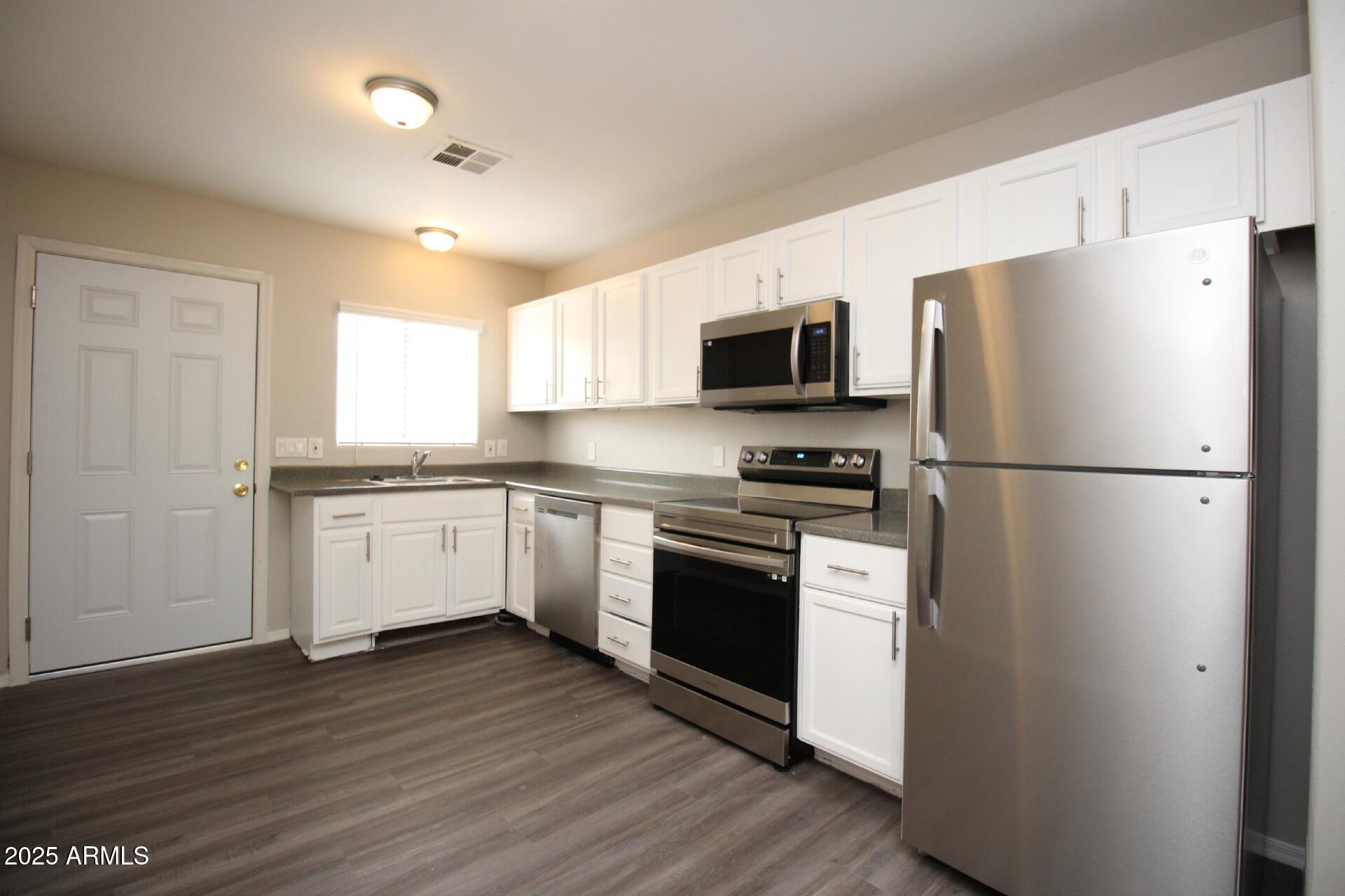 1732 West Maricopa Street, Unit 1 Phoenix, AZ 85007 - Photo 4 of 30 a kitchen with a refrigerator cabinets and wooden floor