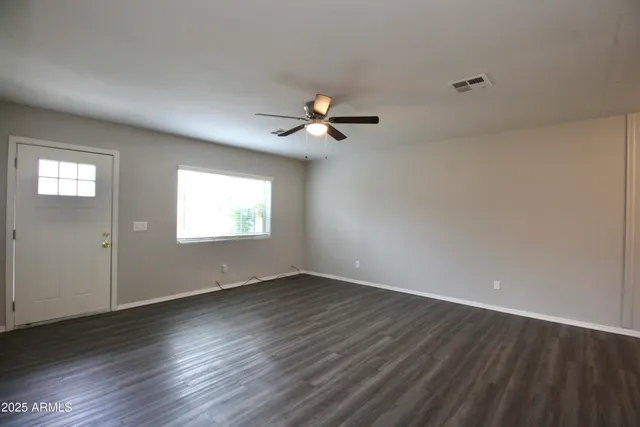 wooden floor in an empty room with a window