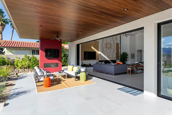 a view of a patio with couches and a potted plant on a table and chair