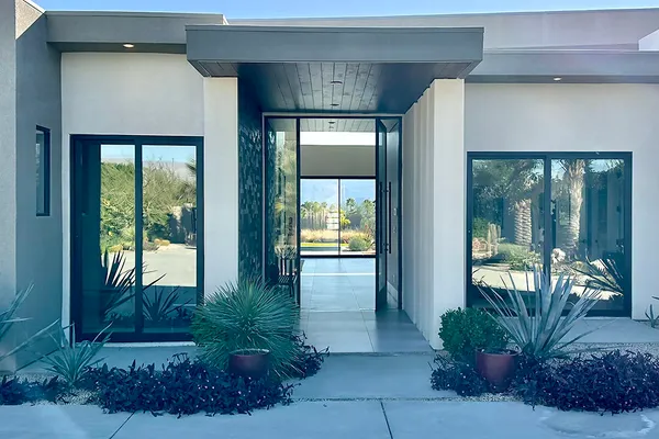 a room with lots of tables a large window and chairs
