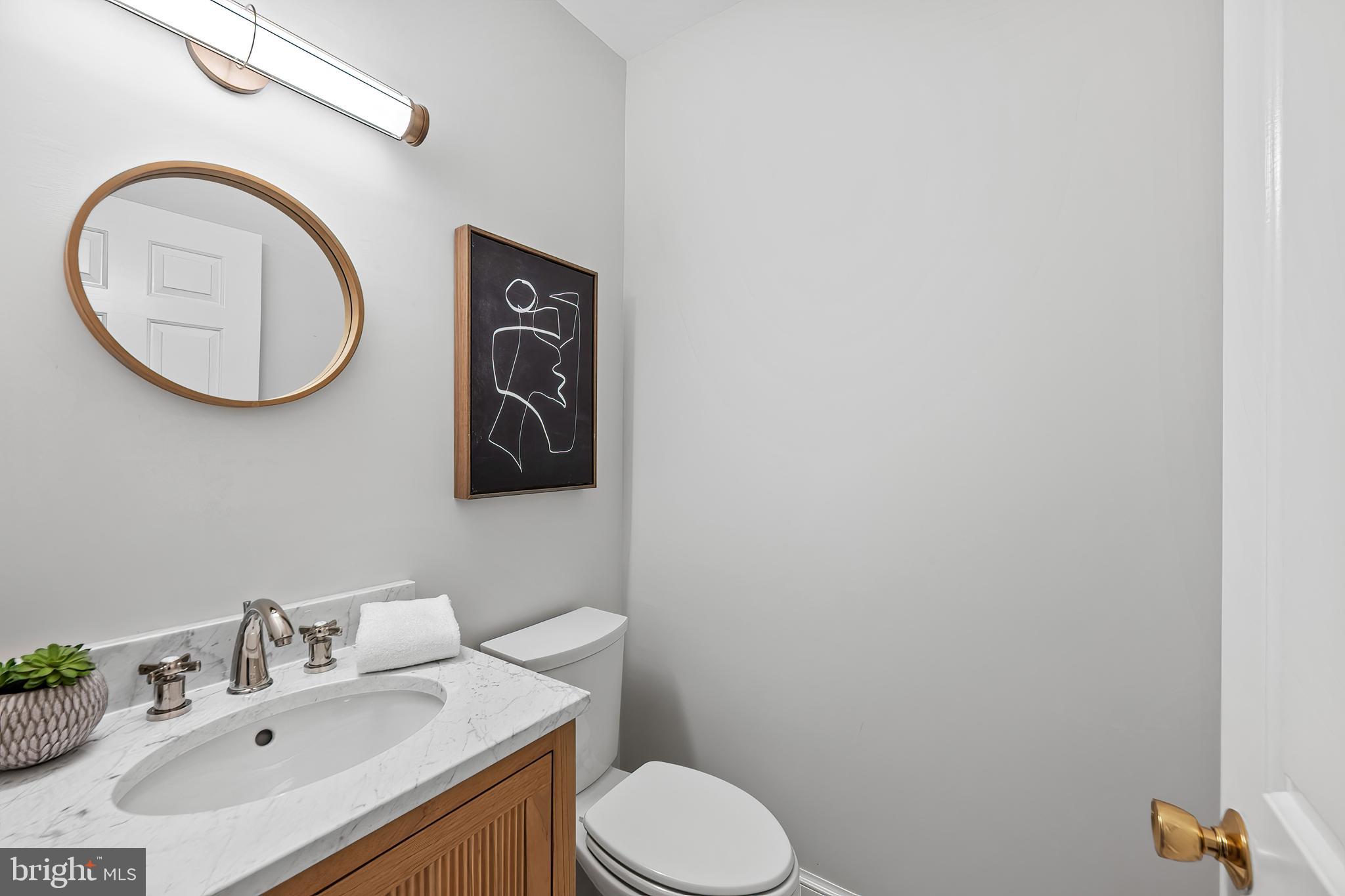 3265 Sutton Place Northwest, Unit B Washington, DC 20016 - Photo 23 of 45 a bathroom with a toilet sink vanity and mirror