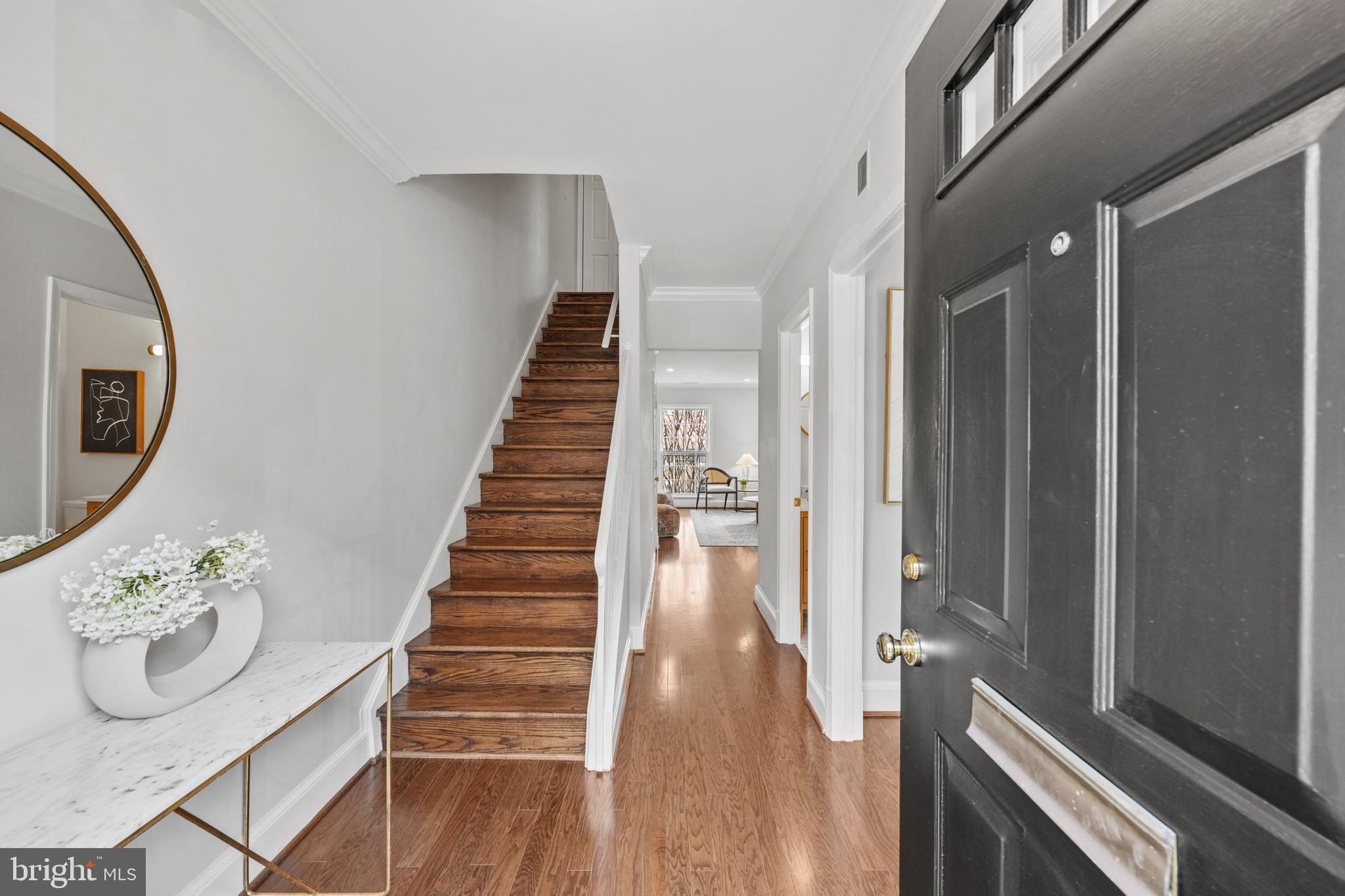 3265 Sutton Place Northwest, Unit B Washington, DC 20016 - Photo 3 of 45 a view of a hallway with wooden floor and staircase