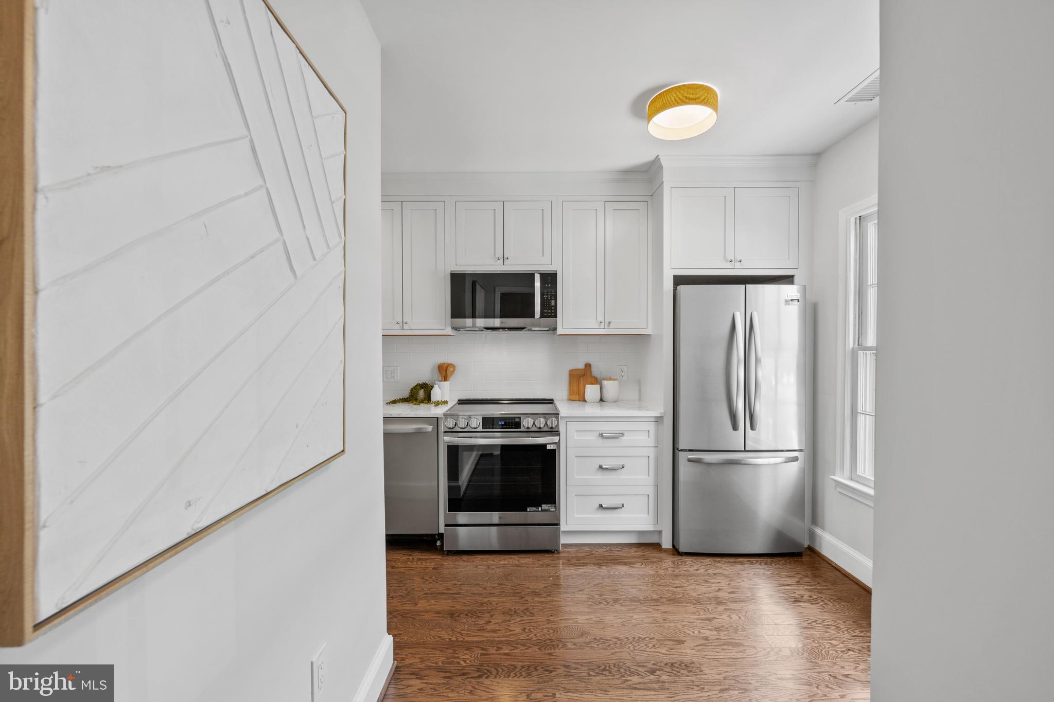 3265 Sutton Place Northwest, Unit B Washington, DC 20016 - Photo 6 of 45 a kitchen with stainless steel appliances granite countertop a refrigerator and a stove top oven