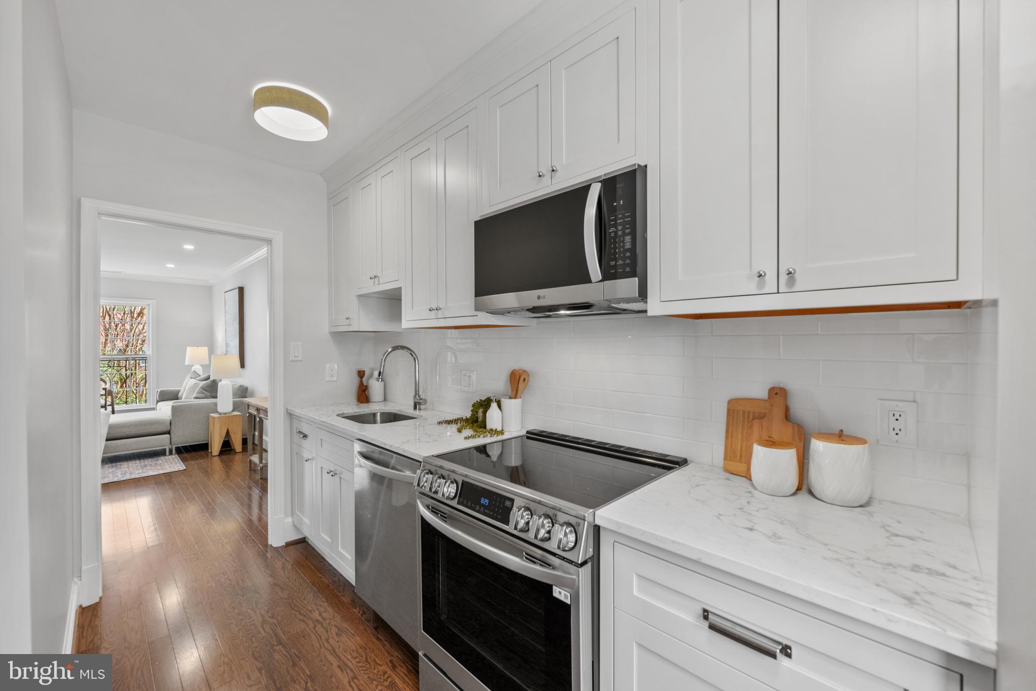 3265 Sutton Place Northwest, Unit B Washington, DC 20016 - Photo 8 of 45 a kitchen with stainless steel appliances granite countertop a sink stove and cabinets