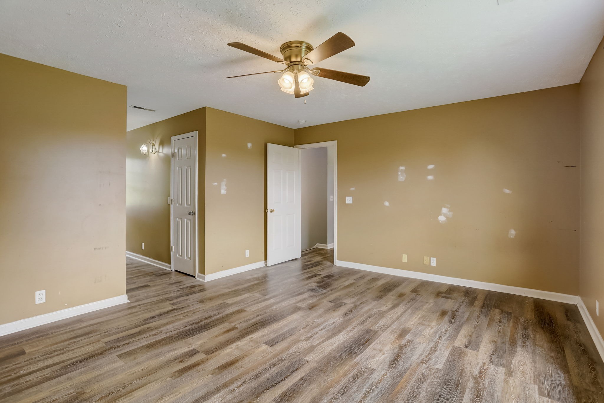 308 Ranch Road Portland, TN 37148 - Photo 18 of 43 a view of an empty room with wooden floor and a ceiling fan