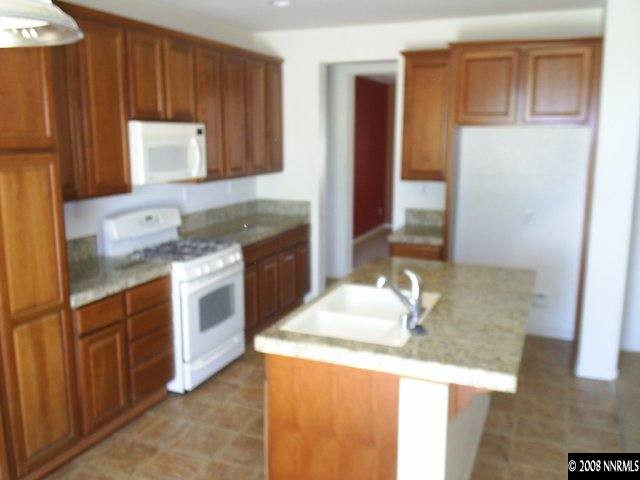 10653 Fire Poppy Circle Reno, NV 89521 - Photo 4 of 9 a kitchen with granite countertop a sink stove and cabinets