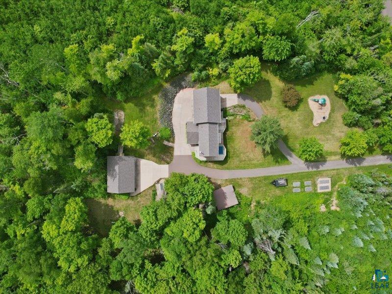 88440 Huron Street Cornucopia, WI 54827 - Photo 4 of 44 Aerial view showcasing a main residence, detached auxiliary building, extensive paved driveway, and multiple landscaped areas