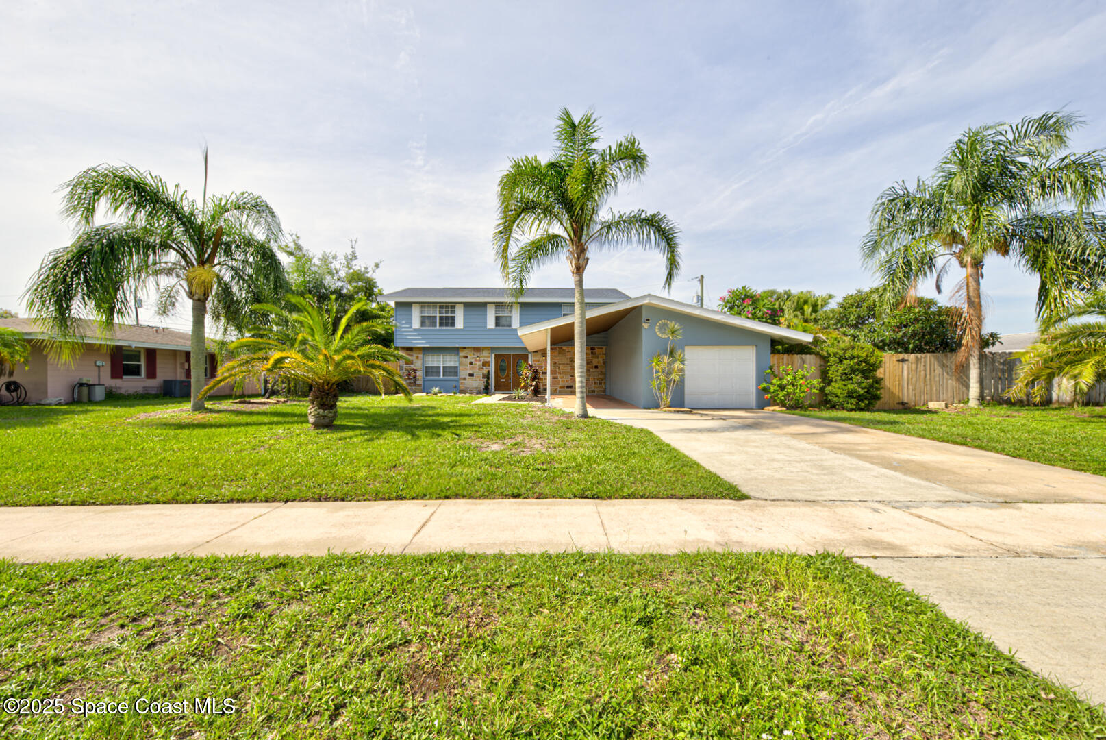 949 Brunswick Lane Rockledge, FL 32955 - Photo 2 of 43 a front view of a house with a garden and palm trees