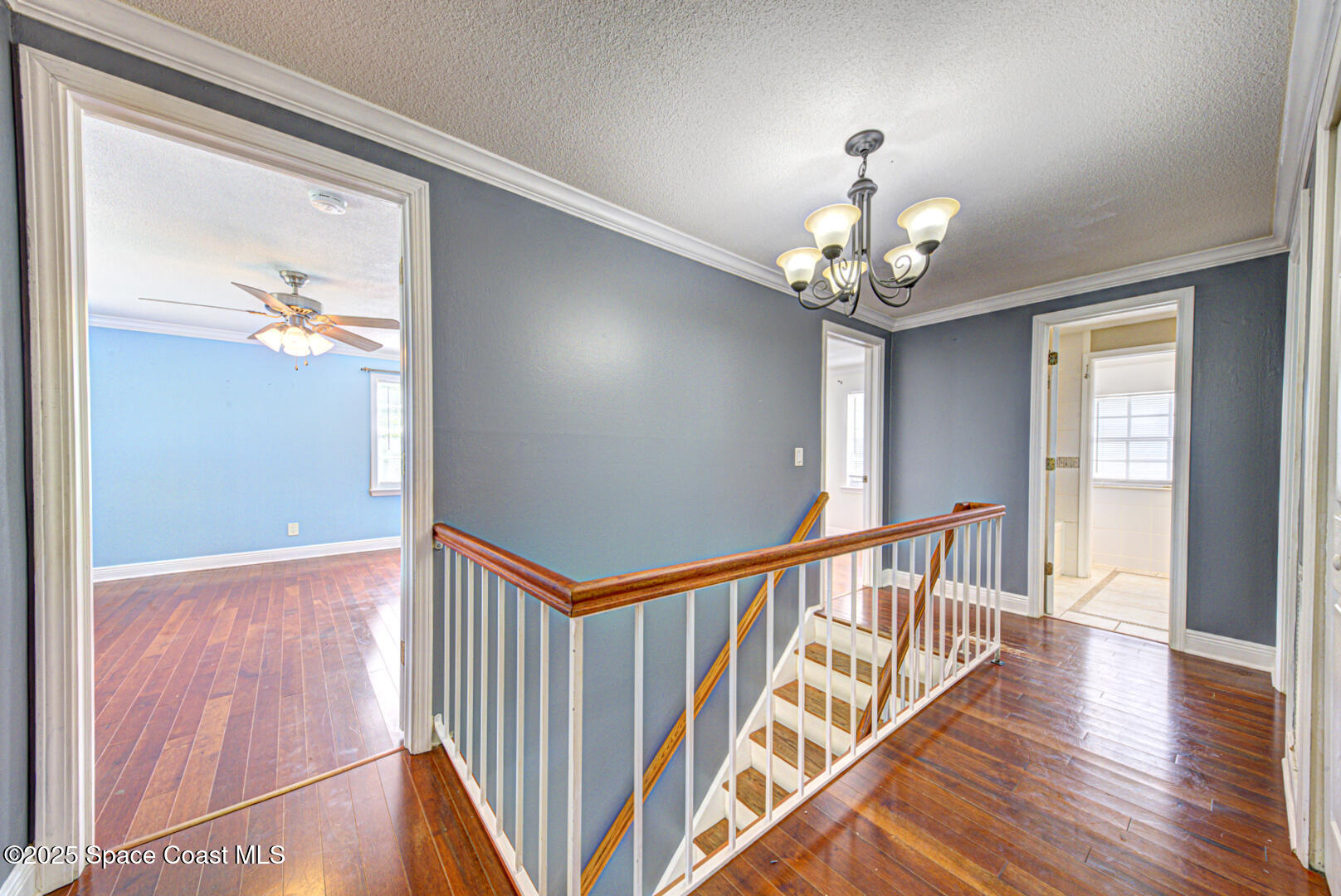 949 Brunswick Lane Rockledge, FL 32955 - Photo 24 of 43 a view of a hallway with wooden floor and chandelier