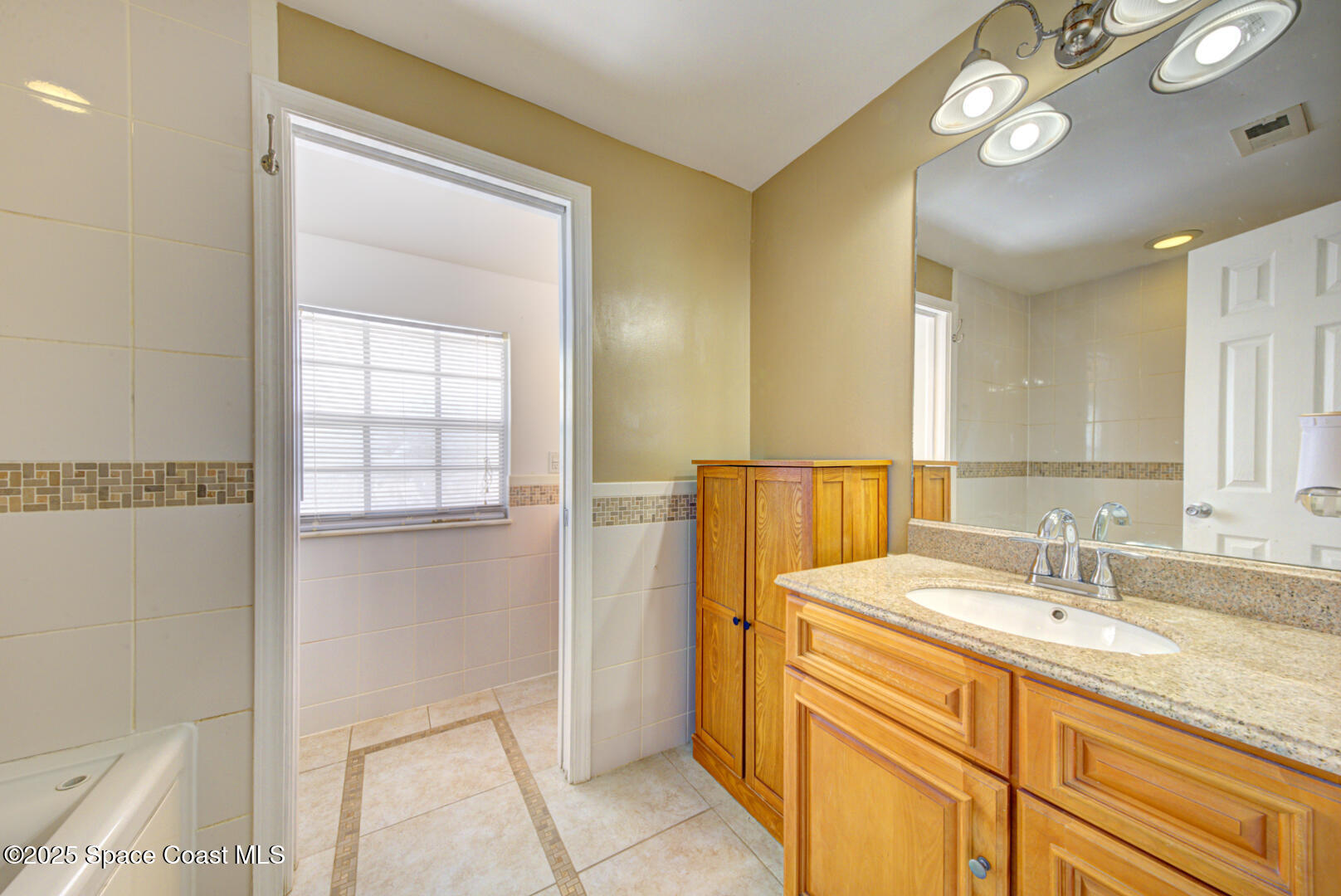 949 Brunswick Lane Rockledge, FL 32955 - Photo 27 of 43 a bathroom with a double vanity sink and a mirror
