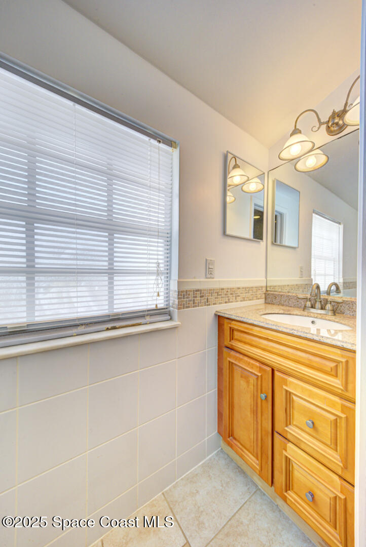 949 Brunswick Lane Rockledge, FL 32955 - Photo 28 of 43 a bathroom with a tub a sink and a large mirror