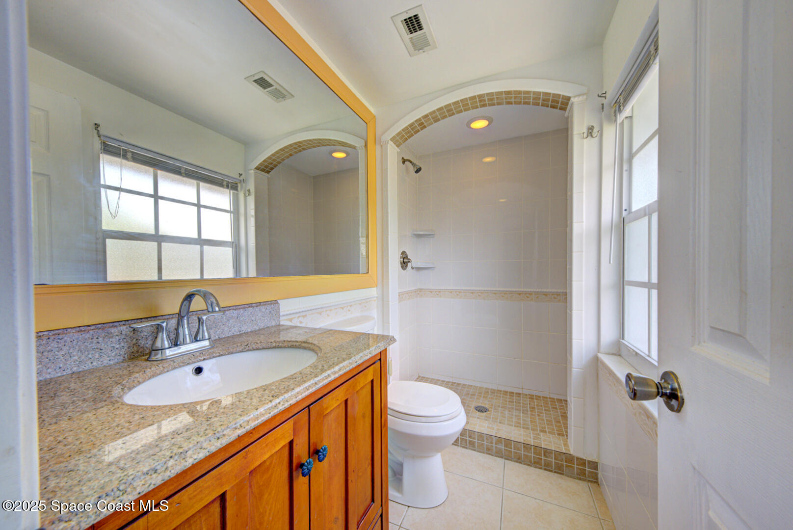 949 Brunswick Lane Rockledge, FL 32955 - Photo 37 of 43 a bathroom with a sink a toilet a mirror and shower