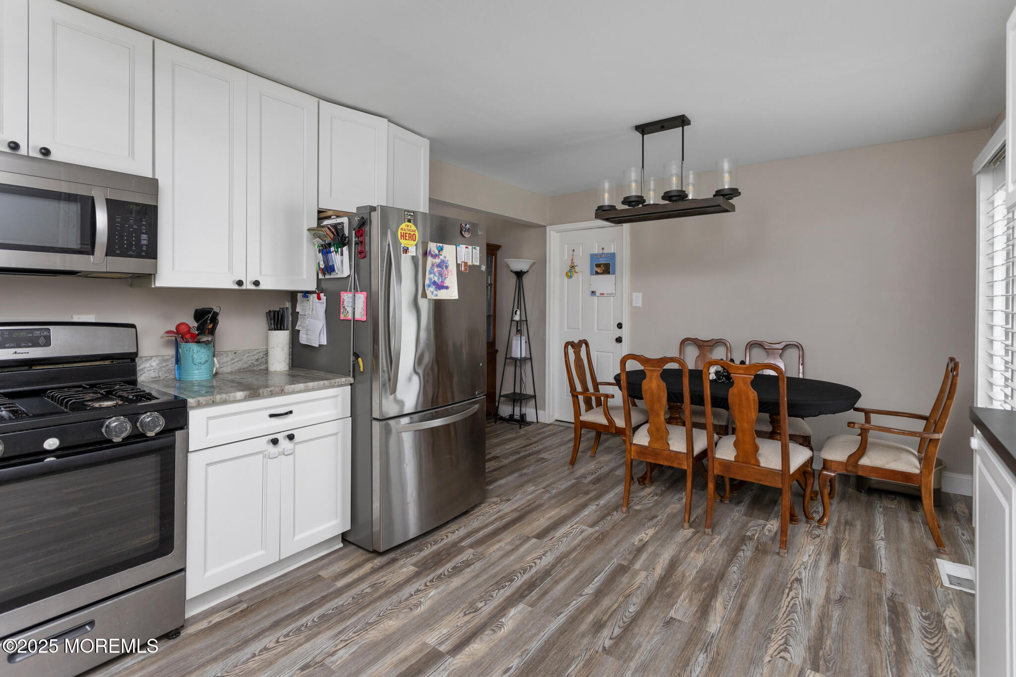 444 Pennington Drive Westampton, NJ 08060 - Photo 11 of 25 a kitchen with stainless steel appliances a refrigerator a stove top oven a dining table and chairs with wooden floor