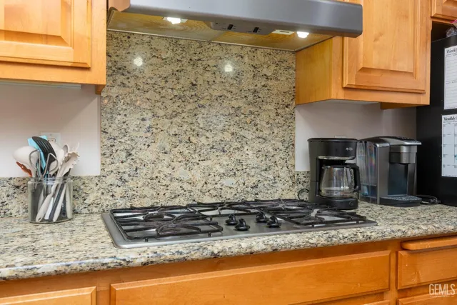 a kitchen with granite countertop a sink and a stove