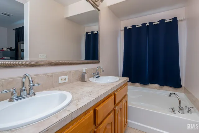 a bathroom with a granite countertop sink and a bathtub