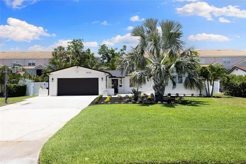 a front view of a house with garden and trees