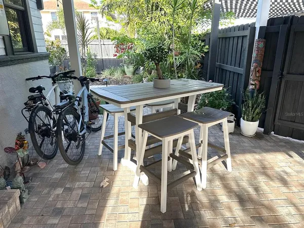 a view of a patio with dining table and chairs