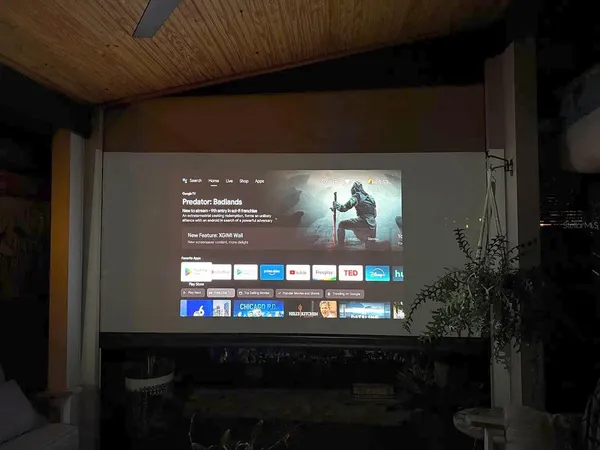 a view of a patio with table and chairs potted plants and floor to ceiling window