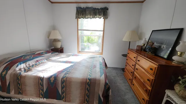 a bed sitting in a bedroom next to a window