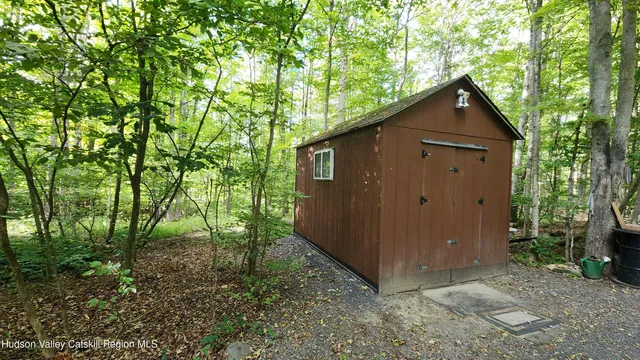 a barn with a small yard and large trees