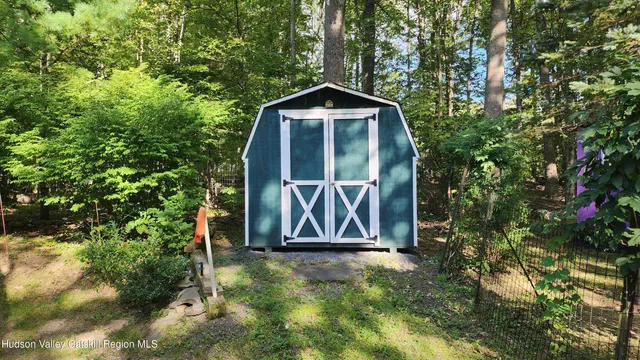 a sign that is sitting in front of a tree