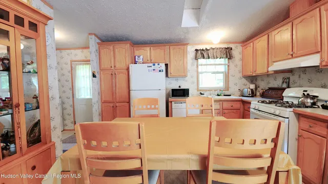 a kitchen with stainless steel appliances granite countertop a refrigerator a stove and white cabinets with wooden floor