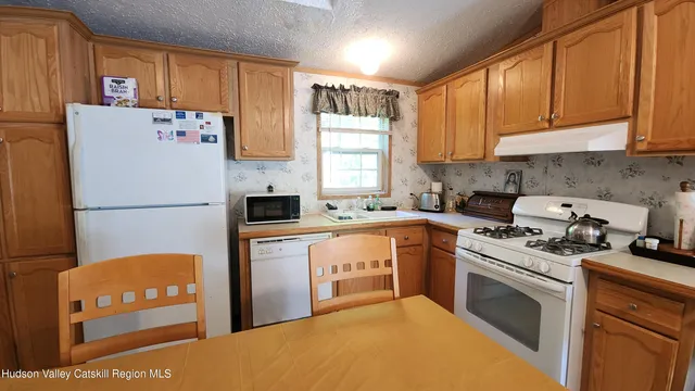 a kitchen with stainless steel appliances granite countertop a refrigerator sink stove microwave and cabinets