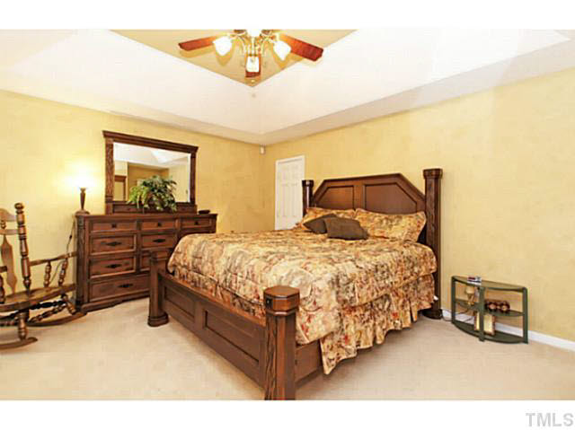 2217 Woodwyck Way Raleigh, NC 27604 - Photo 13 of 25 a bedroom with a bed and dresser with mirror