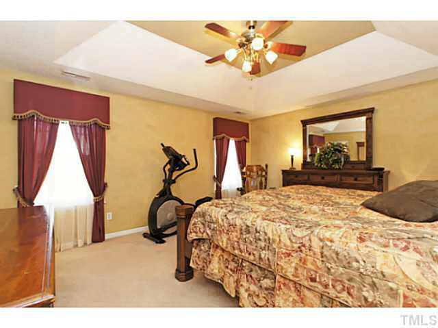 2217 Woodwyck Way Raleigh, NC 27604 - Photo 14 of 25 a bedroom with a bed and a chandelier