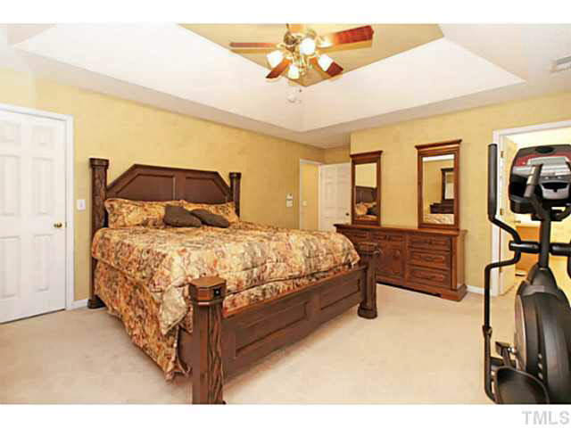 2217 Woodwyck Way Raleigh, NC 27604 - Photo 15 of 25 a bedroom with a bed a dresser next to a window