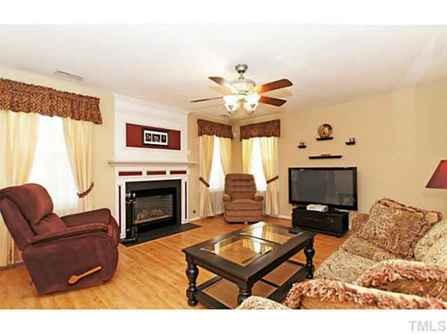 2217 Woodwyck Way Raleigh, NC 27604 - Photo 6 of 25 a living room with furniture a fireplace and a flat screen tv