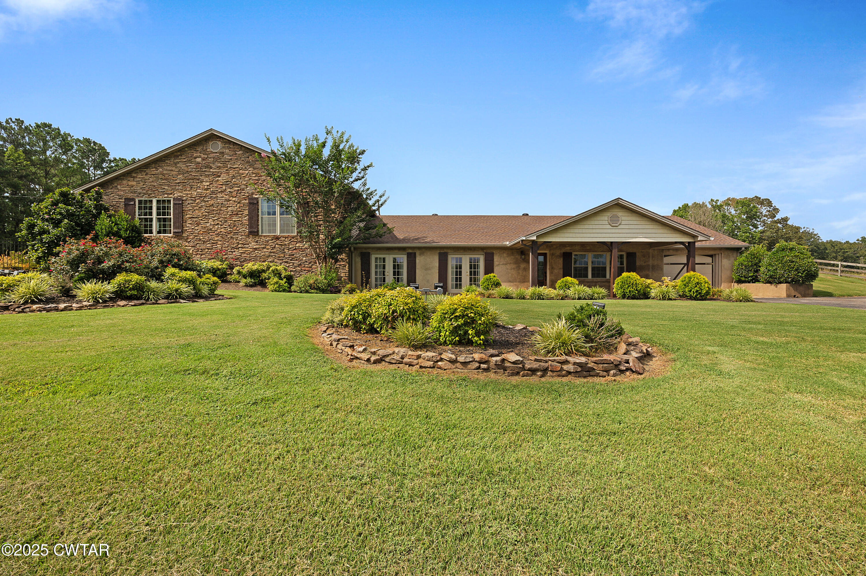 a front view of a house with a garden and yard