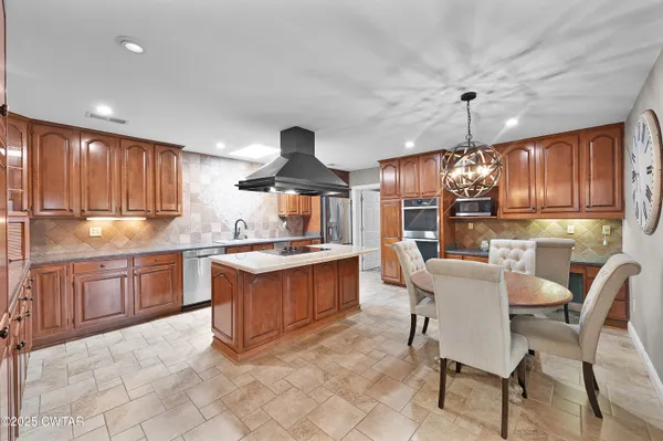a kitchen with granite countertop a sink counter space stainless steel appliances and cabinets
