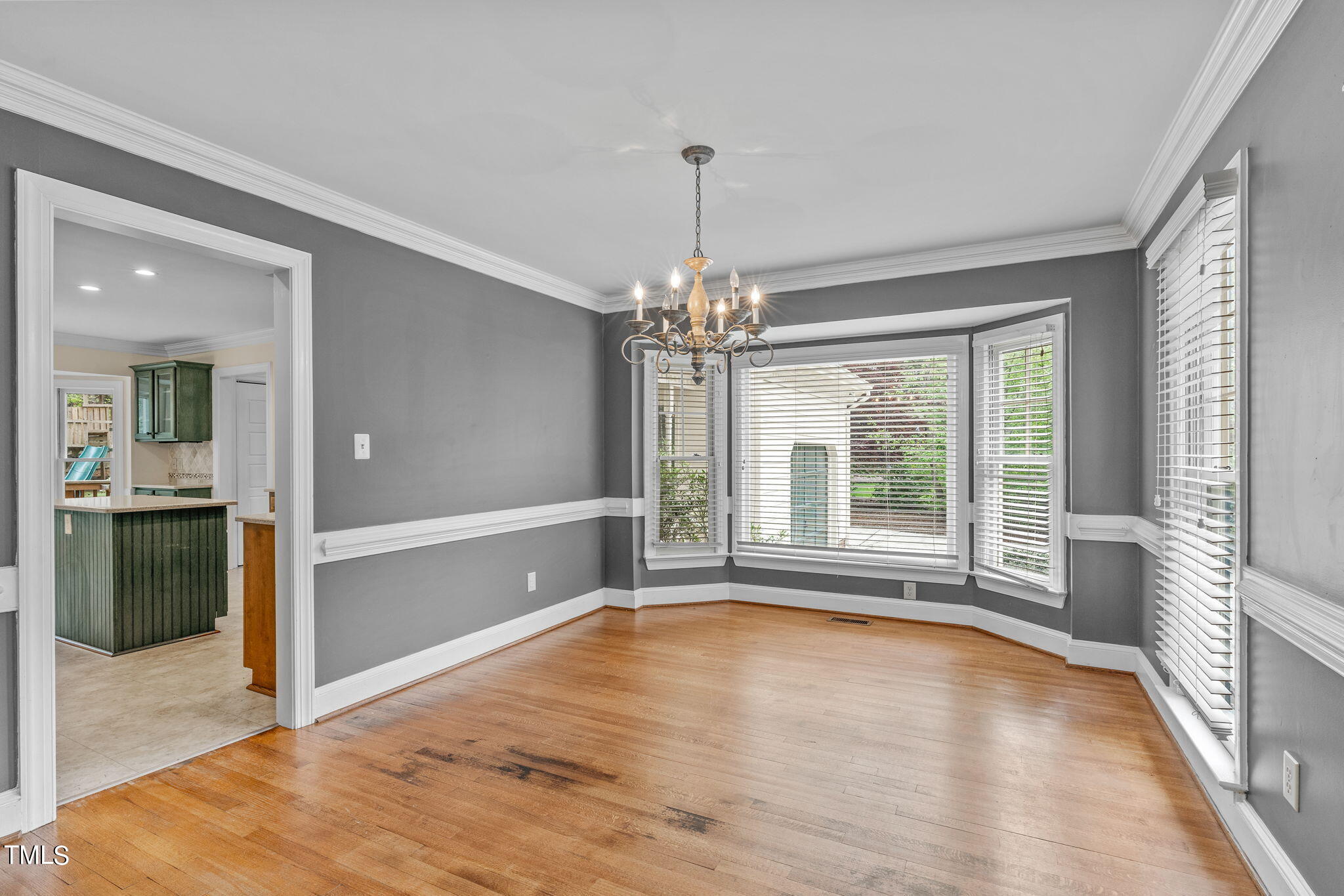 8808 Bickley Place Raleigh, NC 27613 - Photo 6 of 43 a view of an empty room with window and wooden floor